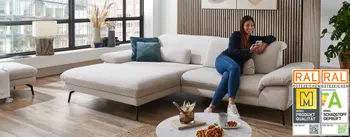 Modernes Wohnzimmer mit heller Eckcouch, Parkettboden und bodentiefen Fenstern – stilvolles, gemütliches Ambiente mit urbanem Flair und warmen Holzelementen